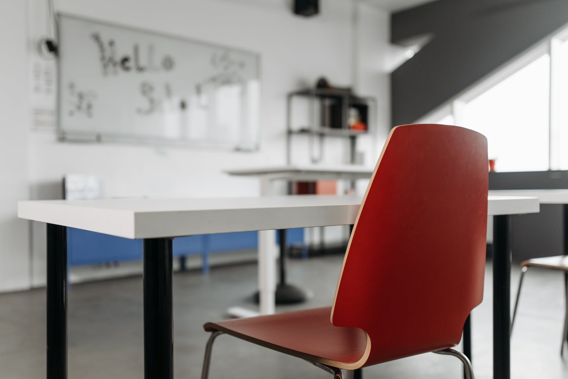 red chair beside white table inside a classroom