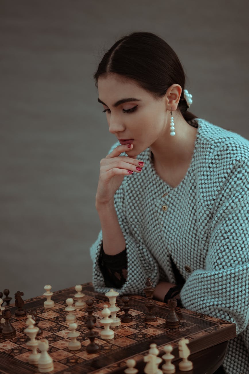 focused woman thinking about next move and playing chess